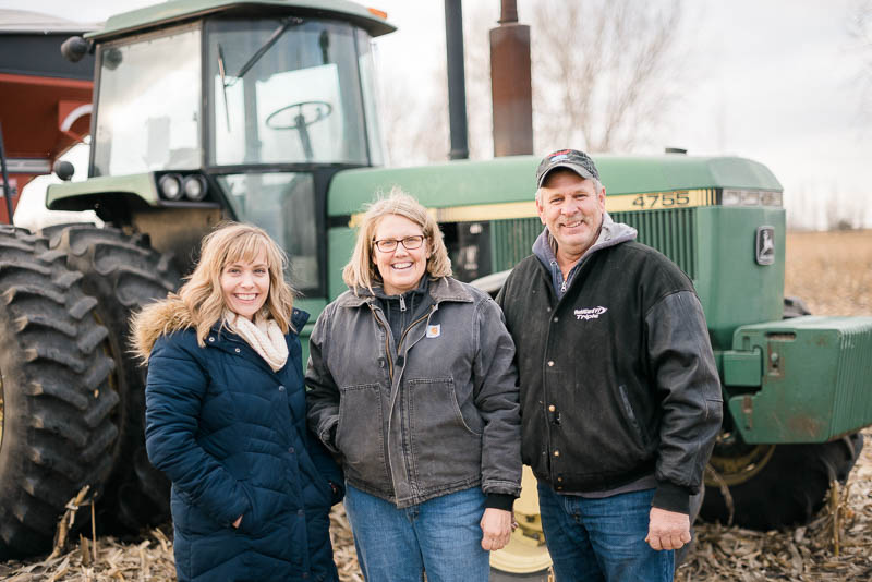 Andrea with South Dakota farmers Peggy and Brad Greenway in front of their tractor at harvest.